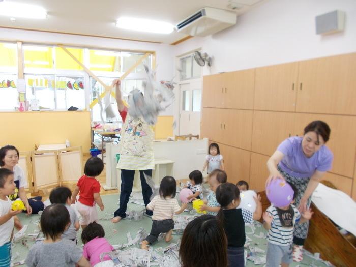 新聞紙や風船で遊ぶ子供達の写真