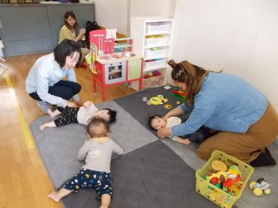 3人の赤ちゃんがマットに寝転がっている写真