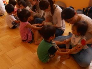 園児達が体験にきた小さな子供達と手をつなぎリズム遊びをしている写真