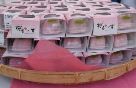 四角い透明のケースに入れられ、並べられている綺麗な桜色の桜もちぃずのお菓子の写真