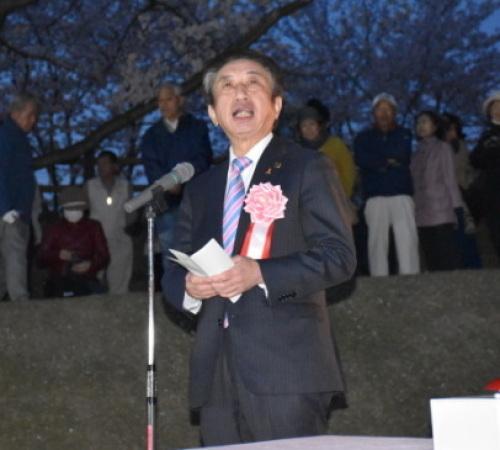 スーツ姿の市長がマイクの前にたち挨拶をしている写真