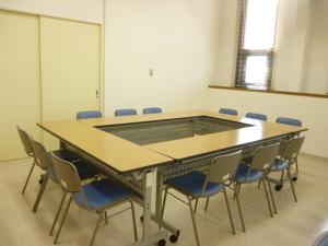テーブルと椅子がロの字にセットされている会議室の写真